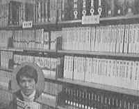 棚に多数の書籍や雑誌が整然と並び、背表紙にはタイトルや番号が印字され、上段にはラベルが付けられた整理された書庫の写真