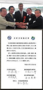 屋内の会議室のような場所で、スーツやジャケットを着用した5人の男性が、手を重ねており、笑顔や真剣な表情を浮かべた記念写真下に、自治体間の友好交流協定書の本文と関係者の署名が掲載された、協定締結の様子を示す写真と、その下に友好盟約の本文と関係者の署名が記された書面が合成された、盟約締結の様子を伝える写真